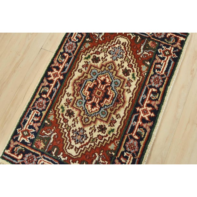 A traditional tribal Heriz rug hand-knotted with an all-wool pile on a cotton foundation. This oriental rug features a...