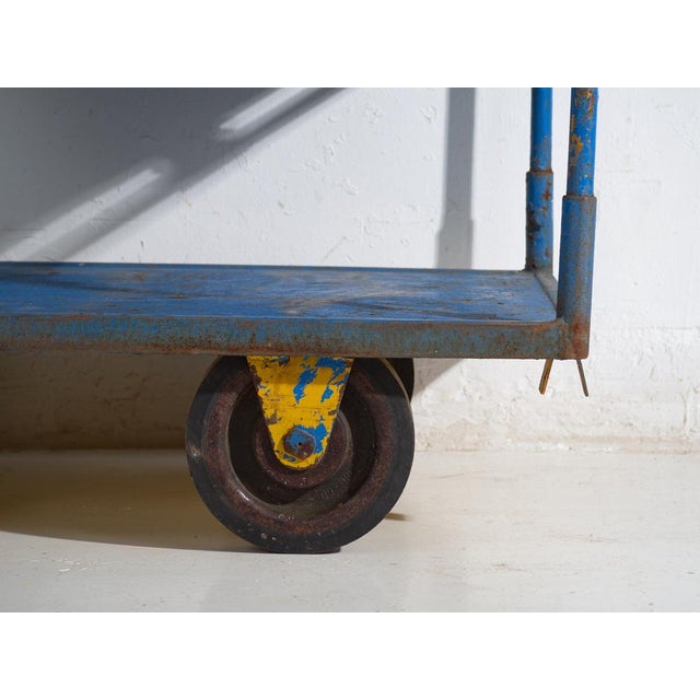 Antique industrial metal cart with three tiers and original wheels, crafted in iron and originating from Central Europe,...