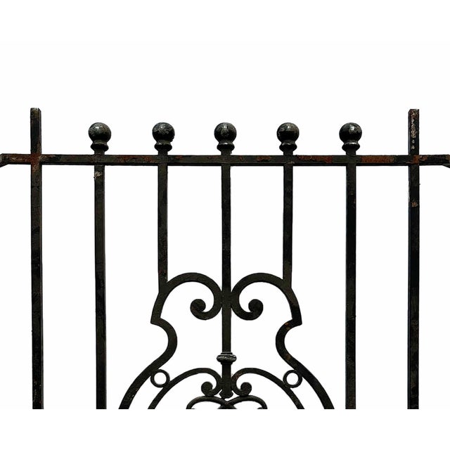 Antique cast and wrought iron window grille. The grille features vertical bars capped with spherical finials and a central...