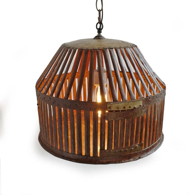 Vintage Indian iron cage basket thoughtfully repurposed into a one-of-a-kind pendant light, celebrating the raw beauty of...