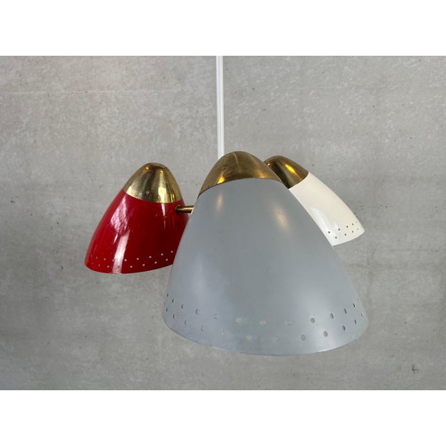 An original Sputnik hanging lamp from the 1950s. 3 large metal shades with perforated edges for a playful light effect....