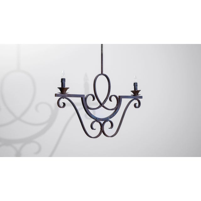 1900s French metal chandelier featuring graceful scrollwork and a minimalist two-arm design. Crafted from wrought iron,...