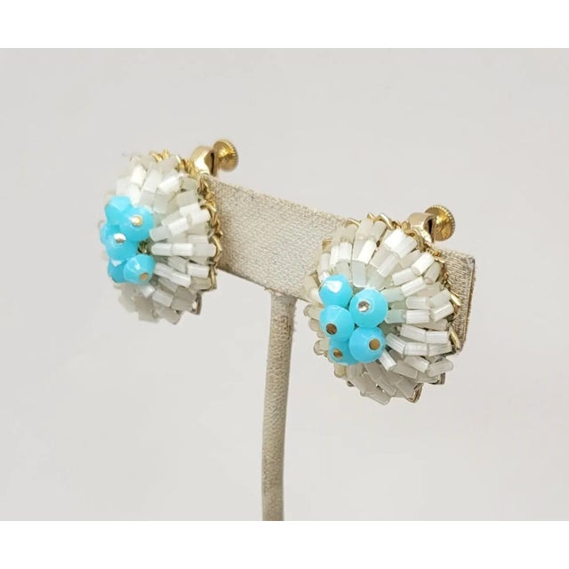 This is part of Chairish’s Costume Jewelry assortment. 1960s goldtone white cylindrical beads with Turquoise beaded center...