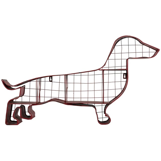 A charming American folk art metal shelf in the shape of a dachshund. Painted red with two wall hangers on the back....