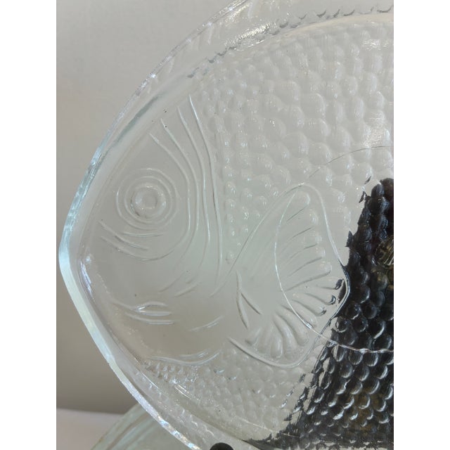 A bold and playful set of twelve mid-century clear pressed glass fish plates, attributed to Indiana Glass Company....