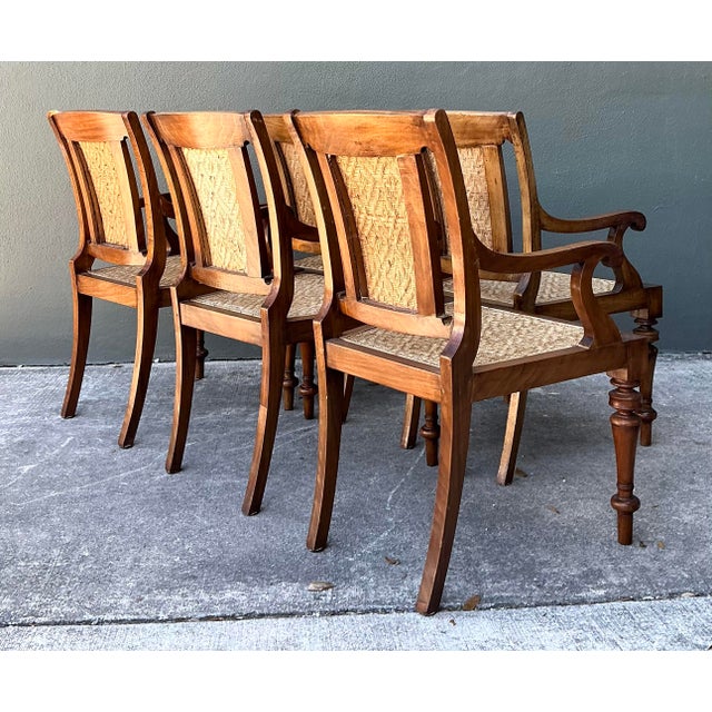Elevate your dining space with this stately set of five vintage Anglo-Indian dining chairs, a masterful blend of British...