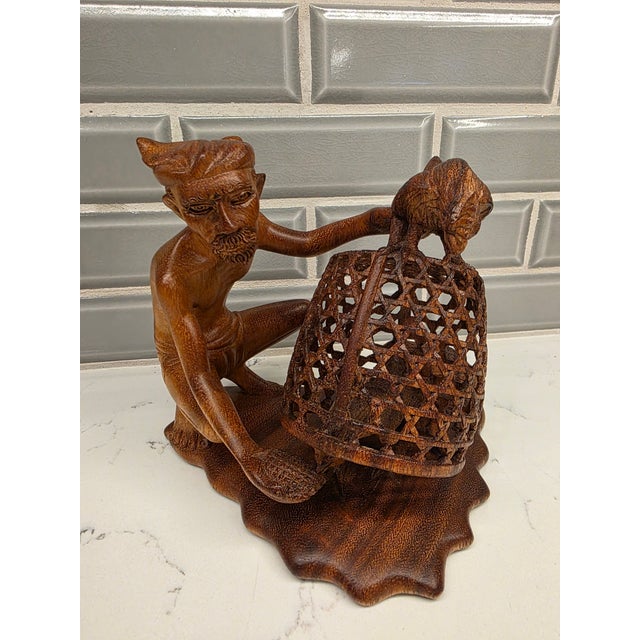 An extraordinary, highly detailed mid-century Balinese expressionist realism genre sculpture depicting a traditional...