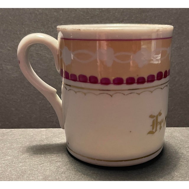 Late 19th century lusterware cup, with maroon, light yellow and gilt decoration; inscribed "For a Friend." Combined...