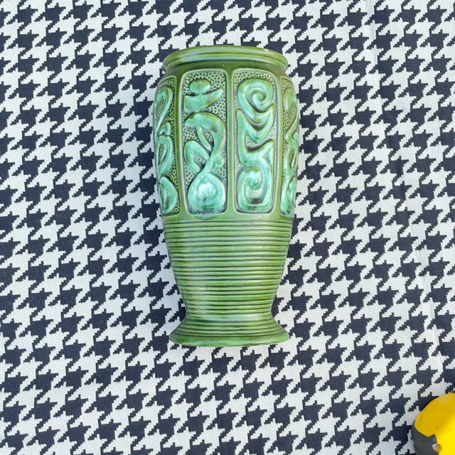 A green Japanese-made ceramic vase with an abstract design circling the top half. I saw a pair of lamps with the exact...