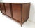 A Mid Century walnut nine drawer dresser chest with unique built in pulls blending in with the streamline style showing...