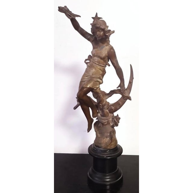 Elegant antique French bronze sculpture representing “La Nuit” (The Night), depicted as a graceful female figure seated...