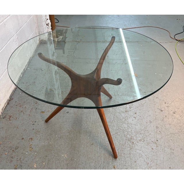A striking blend of organic form and modern craftsmanship, this sculpted walnut dining table draws inspiration from the...