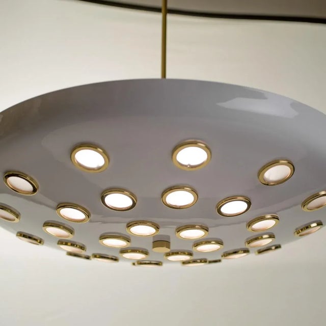Large flying saucer fixture composed of 30 small frosted lenses and brass rings. Arredoluce produced these style...