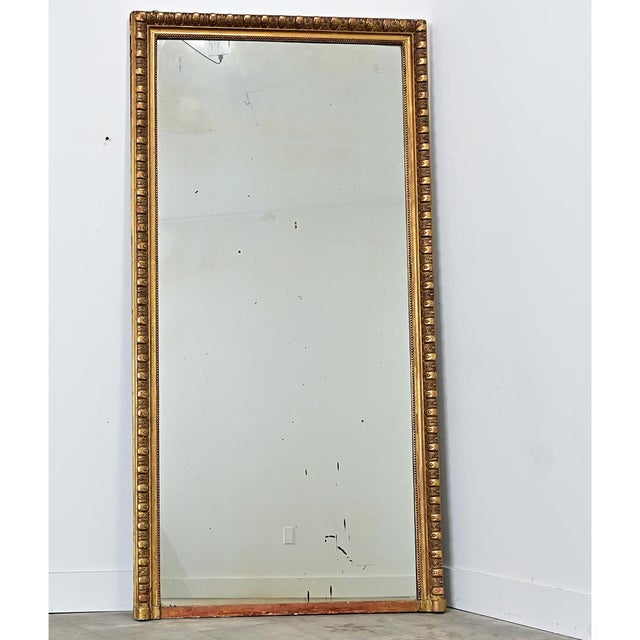 A massive 19th century French gold gilt mantel mirror of proportionately thick egg & dart molding around the original...