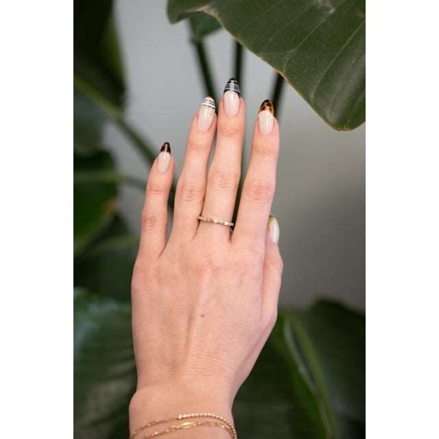 A sleek 14K yellow gold band featuring elegant baguette-cut diamonds in a clean, modern setting. Perfect for stacking or...