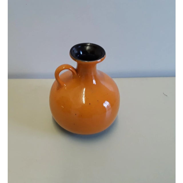 This orange and brown jug from Jasba is numbered '1231 20'. Labeled by Maker,This piece has an attribution mark, I am sure...