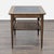 American of Martinsville mid-century occasional table with a pull-out drawer and a caned shelf underneath. The table is...