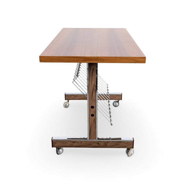 We are offering a beautiful side table from the 1960s for sale. The piece features a magazine rack and four small casters,...