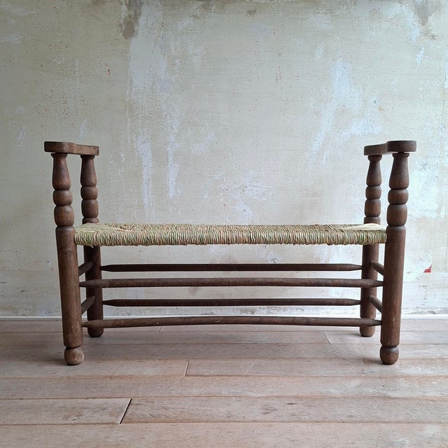 This antique wooden bench with new rush seat is in good condition. Originating from France. The now slightly light green...
