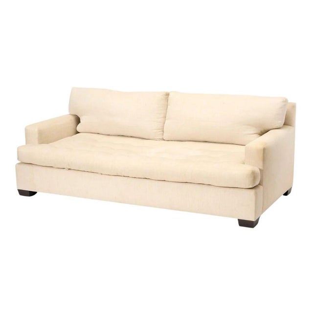 A John Boone contemporary upholstered sofa in cream cotton fabric with a single bench seat, two back cushions and track...