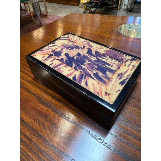 Beautiful vintage rectangular wooden box featuring a striking tortoiseshell-patterned inlay framed in dark wood. The rich...