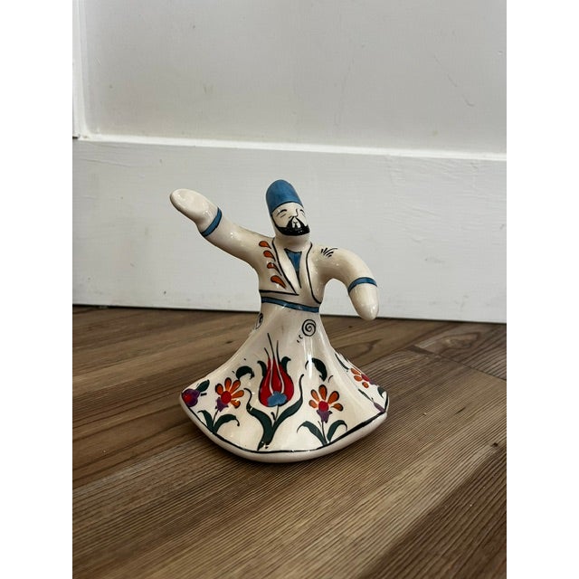 Small, handmade ceramic Whirling Dervish figurine from Kütahya featuring a smooth white glazed finish and an attached gold...