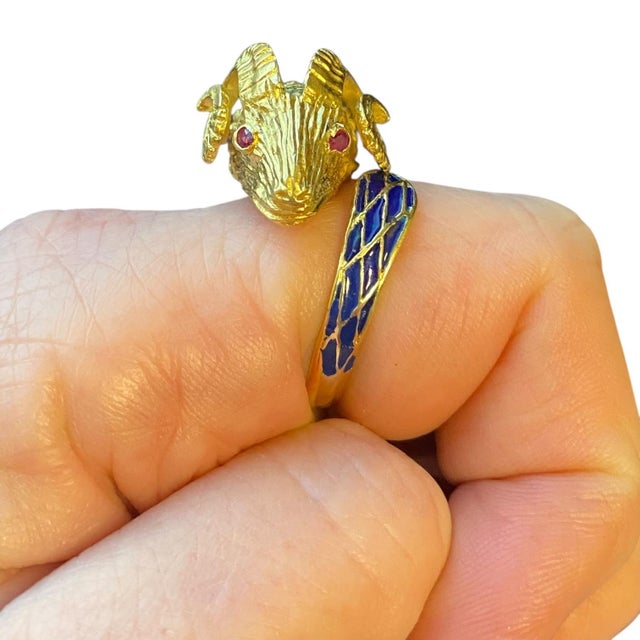 Vintage statement ring crafted in 18K yellow gold, featuring a detailed ram's head design. The eyes are set with round-cut...