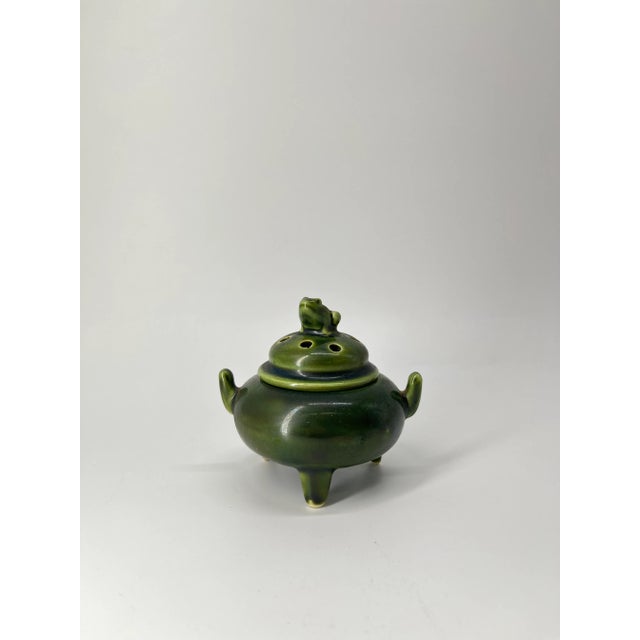A captivating vintage Japanese ceramic incense burner (koro) in a deep, rich green glaze. The burner stands gracefully on...