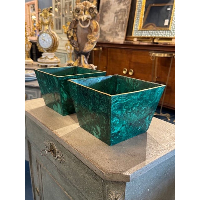 This product is a pair of French malachite planters with brass trim, adding a touch of elegance to any space. These...