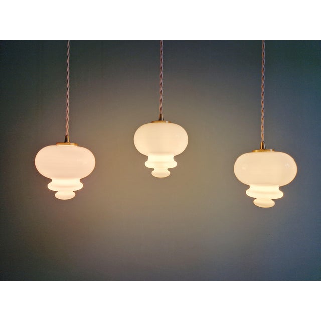 Trio of 1960s Scandinavian pendant lights in white opaline glass, with a rather unique bulbous shape. Each pendant has...
