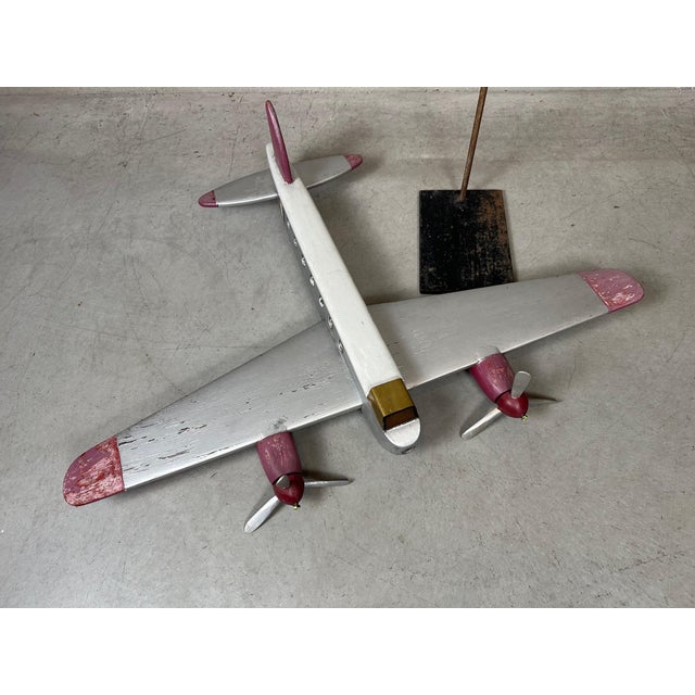 Large wooden toy airplane. Visible signs of use but no less decorative. Mounted on a high slender support. Wingspan: 97cm....