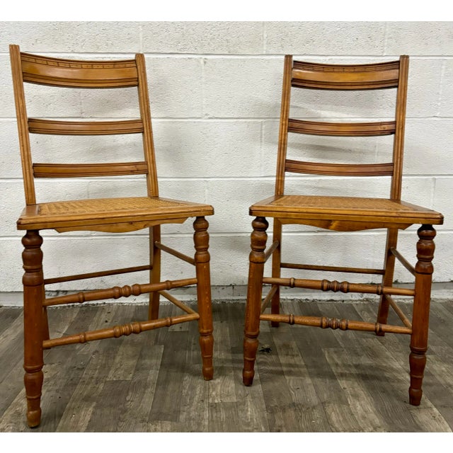 This is a stunning pair of vintage Colonial style Ladderback dining chairs with caned seats. They feature beautifully...