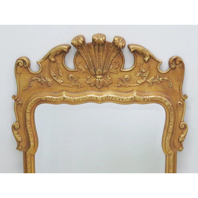 Gilt carved frame with plumes. Beveled mirror.