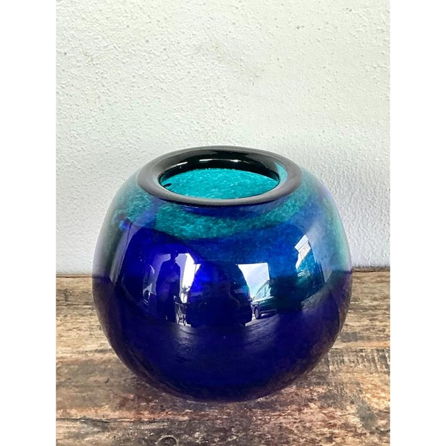 This vintage glass sphere vase presents a bold, orb-like form with a compact, gently narrowed opening at the top, creating...