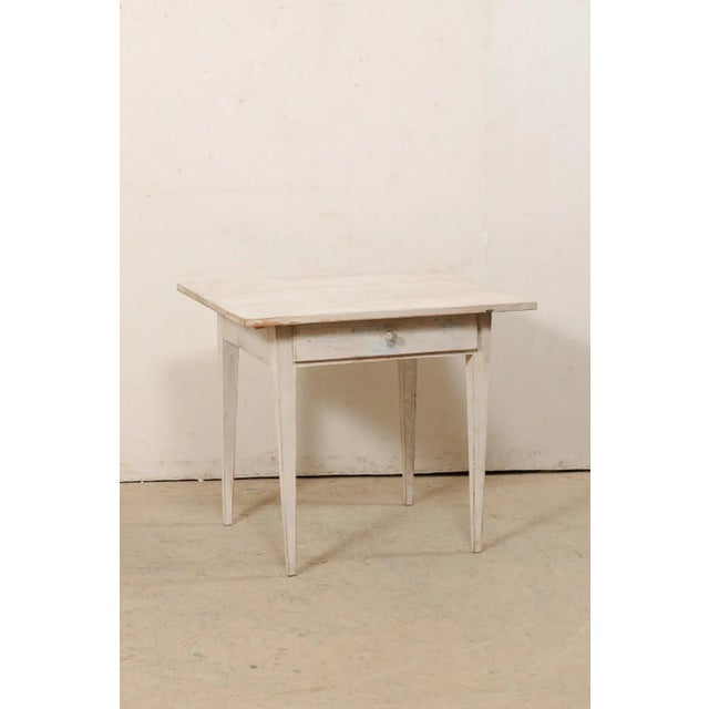 A Swedish period Gustavian painted wood table from the early 19th century. This antique table from Sweden has been...