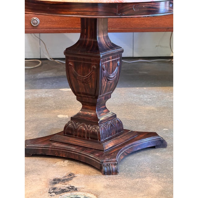 A round rose-veined marble top on a grained faux rosewood pedestal — the dark streaking is well executed and gives the...