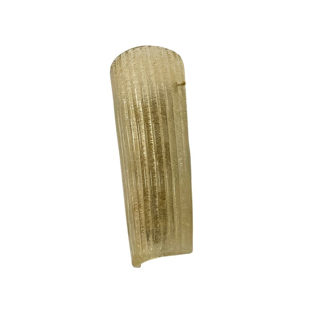 Pair of Murano glass wall sconces with a rectangular profile and tile shape. They feature a golden amber tone with a...