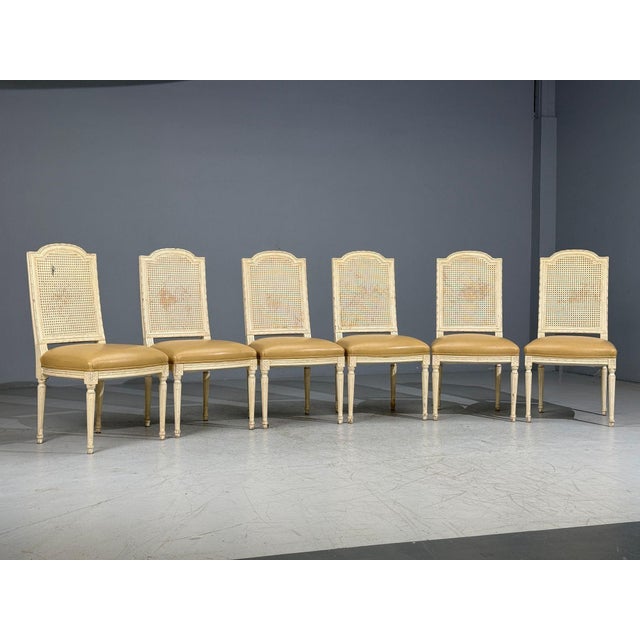 Louis XVI Style, Six Dining Chairs, Painted Wood, Cane, Leather, USA, 20th c. Set of six Louis XVI style carved wood,...