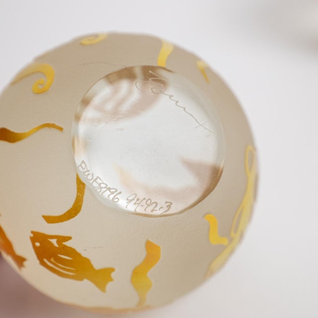 A beautiful signed Mid-Century Modern art glass paperweight, featuring a frosted crystal orb with embedded gold fish and...