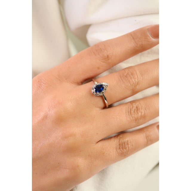 This refined Art Deco-style ring features one pear-shaped blue sapphire weighing 1 carat, beautifully set in 14k white...