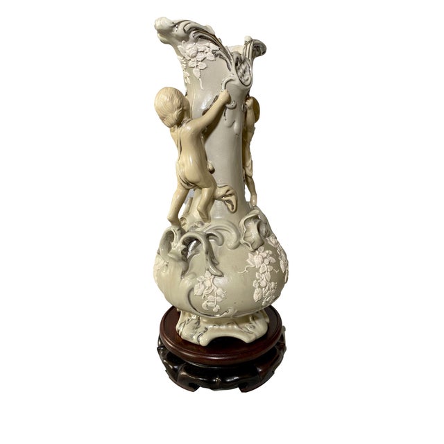 An exquisite 19th-century Villeroy and Boch salt glaze vase featuring delicate climbing cherubs adorning each side of the...