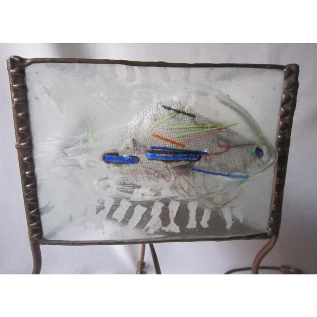 Incredible art glass lamp with three panels of hand blown glass encased in a copper frame. The lamp holds a single,...