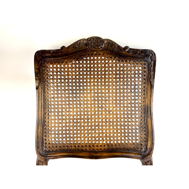 A Louis XV style side chair with a beautifully carved walnut frame, featuring a floral crest, shaped apron, and cabriole...