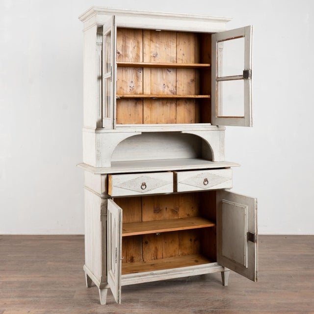 19th century Danish cabinet cupboard crafted in pine. The cabinet features a newer professionally applied light gray...