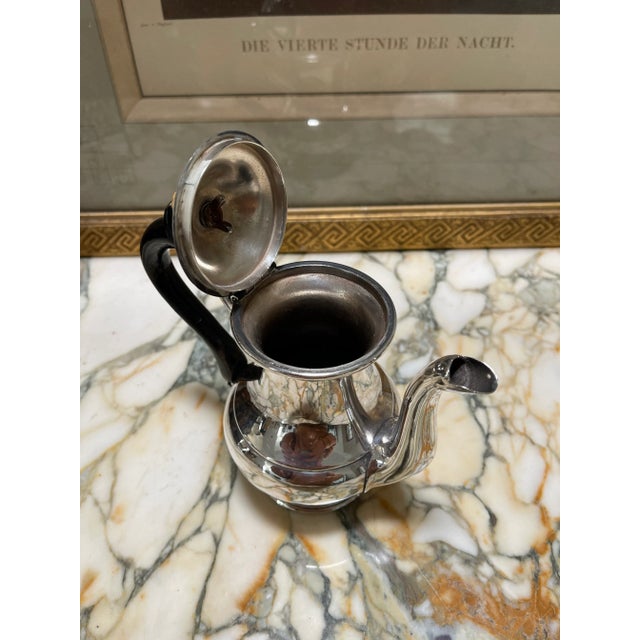 Beautiful small silver plated teapot with a lot of character. - small ivory top with a black wooden handle. Bottom has a...