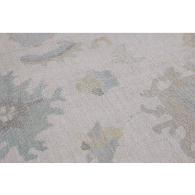 This modern Turkish Oushak rug is a stunning piece of art that has been handwoven using traditional techniques by skilled...