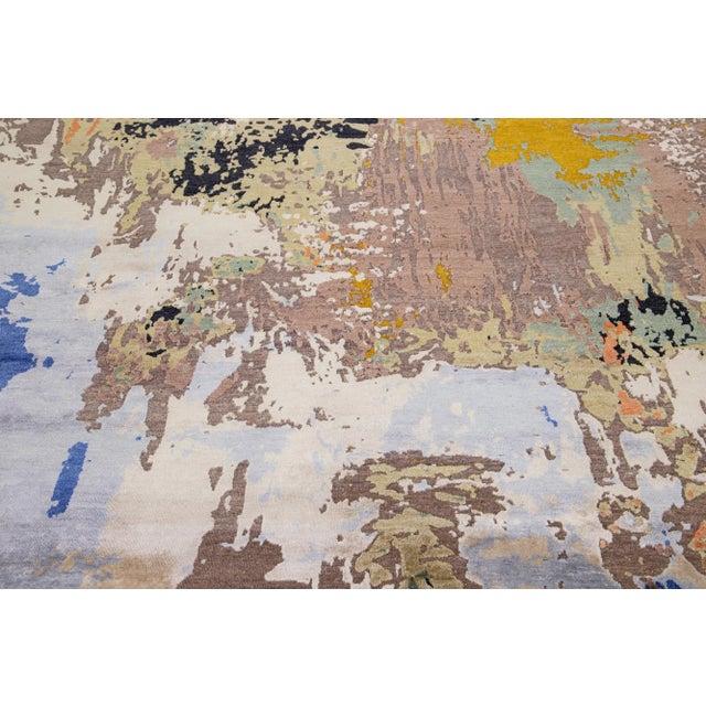 This rug showcases a blend of Indian wool and silk, boasting a multicolored field and abstract patterning. Its composed...