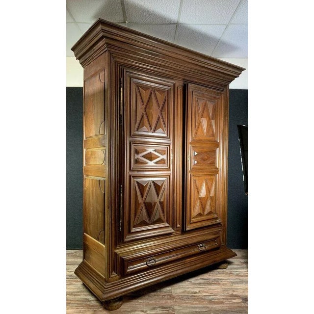 Burgundy cabinet from the Louis XIII period with diamond-shaped tips. Front opens with two doors and one drawer. Decorated...