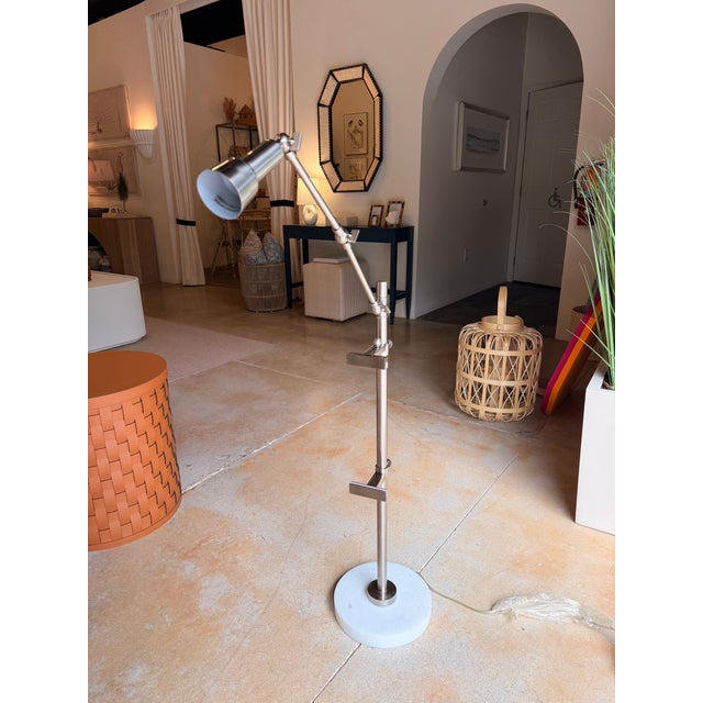This contemporary industrial-style adjustable floor/table lamp combines sleek functionality with refined materials....