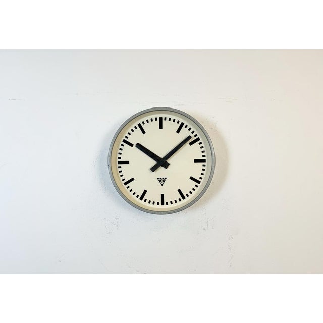 This wall clock was produced by Pragotron in former Czechoslovakia during the 1960s. It features a grey hammerpaint metal...